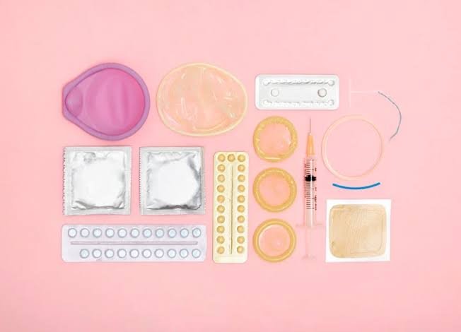 Diversos métodos contraceptivos organizados sobre fundo rosa, representando a contracepção de longa duração